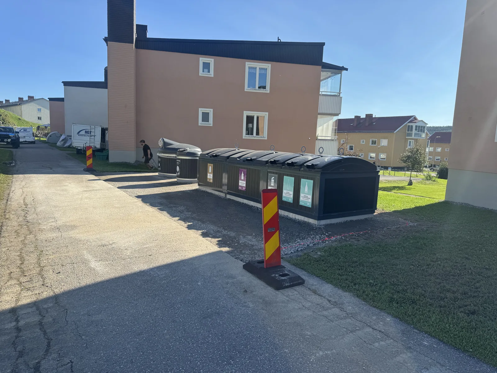 Monterade underjordsbehållare med grusad yta klar för asfaltering, sedd från infartsgången